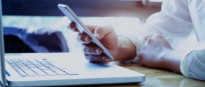 Businessman using laptop and mobile phone.